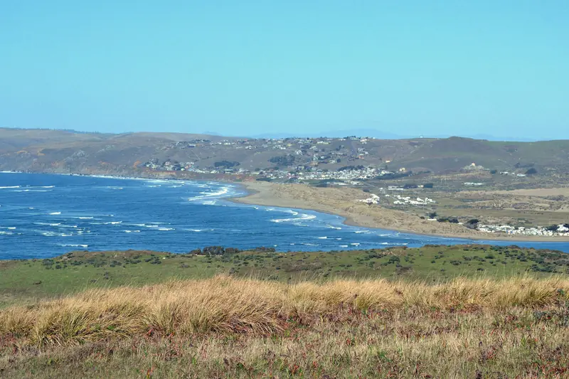 Photo of blue water and green hills at Tomales Bay